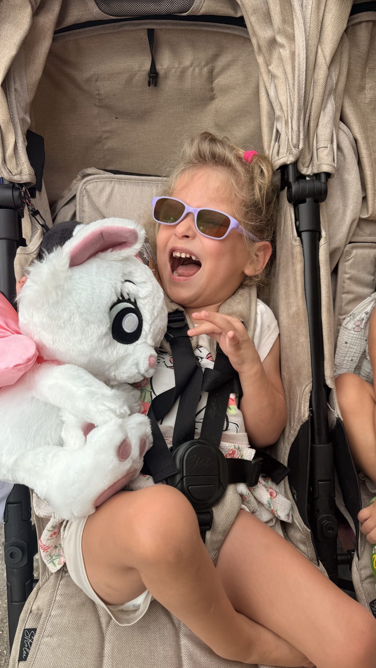 Emma Rodger smiling as she hugs her Marie plush