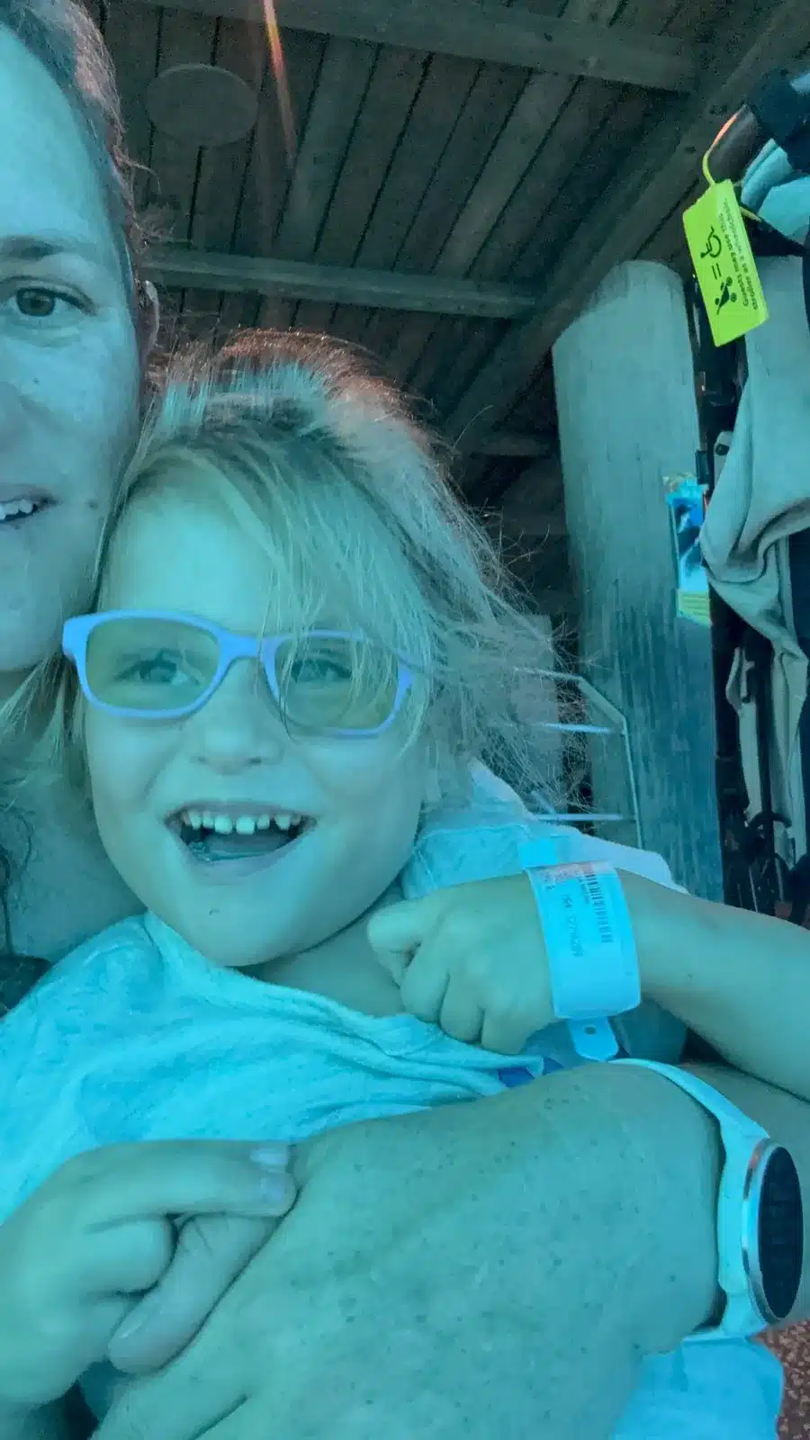 Emma, smiling big in blue glasses, cuddled up close at the aquarium Emma, smiling big in blue glasses, cuddled up close at the aquarium